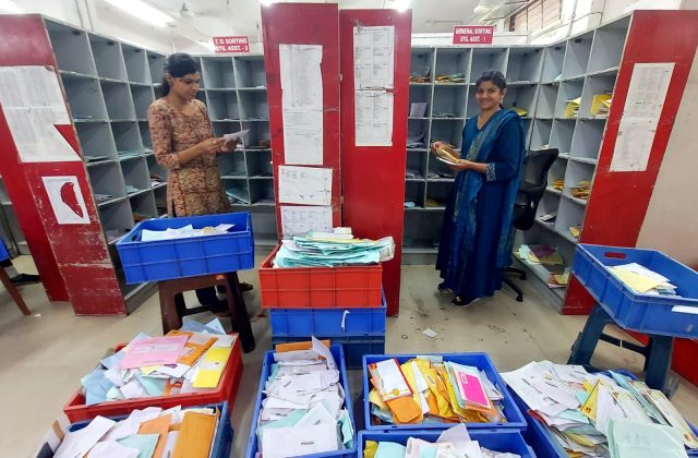 Colorful Rakhi threads being prepared for dispatch at a post office for Raksha Bandhan.